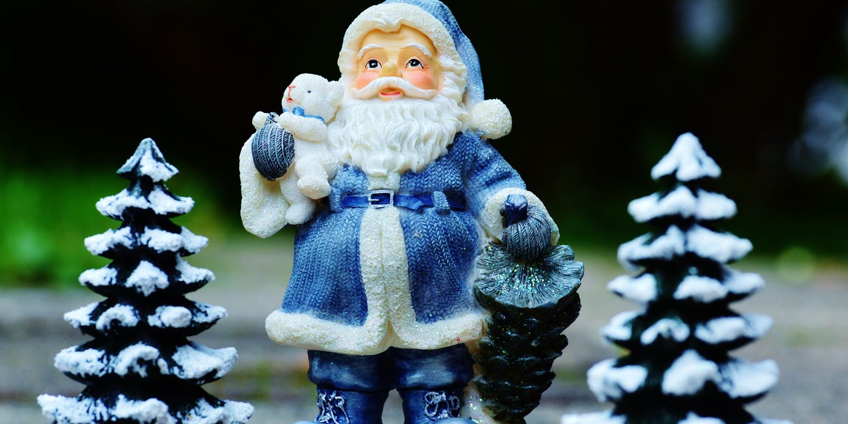 Close-up of a Santa statue next to Christmas trees
