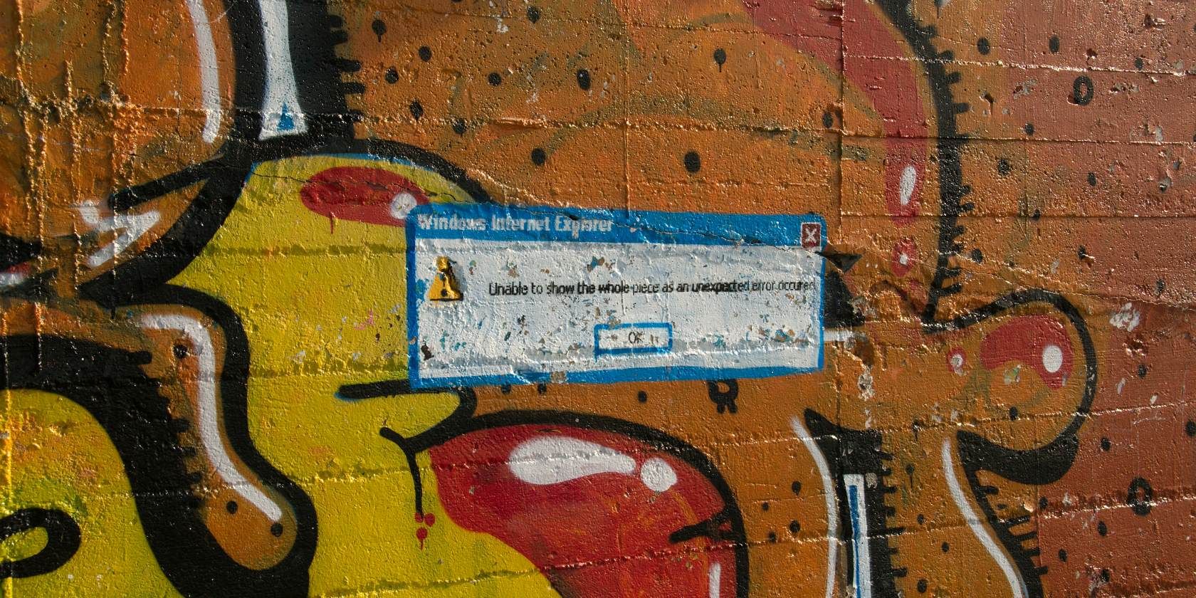 Graffiti on wall showing Windows error dialog box