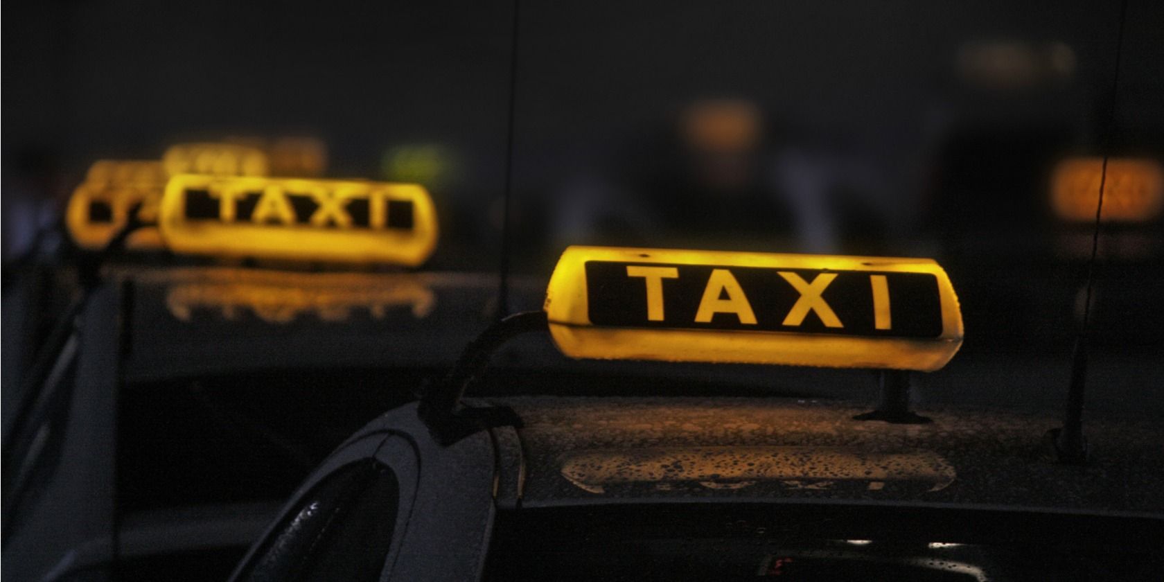 Row of taxi roof lights lit at night