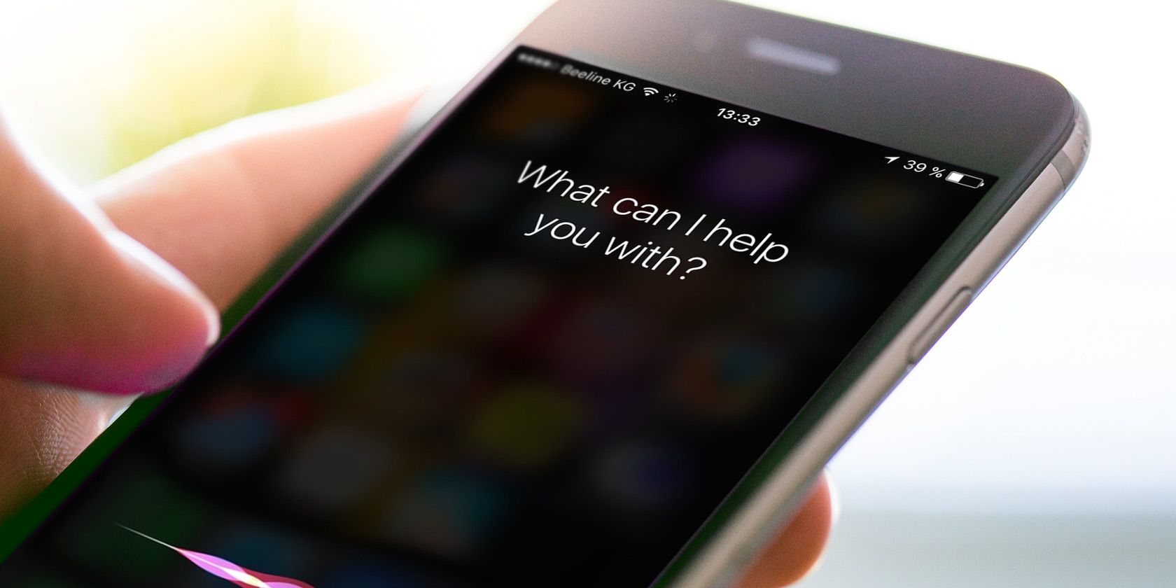 A person holding an iPhone with the voice assistant Siri activated, asking about iPhone tracking.