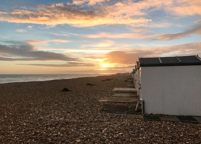 sunset on beach with sheds