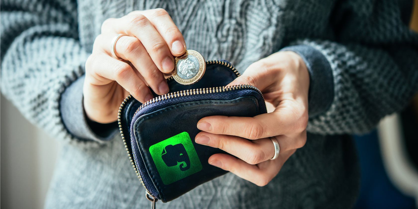 Person pulling money out of an Evernote purse