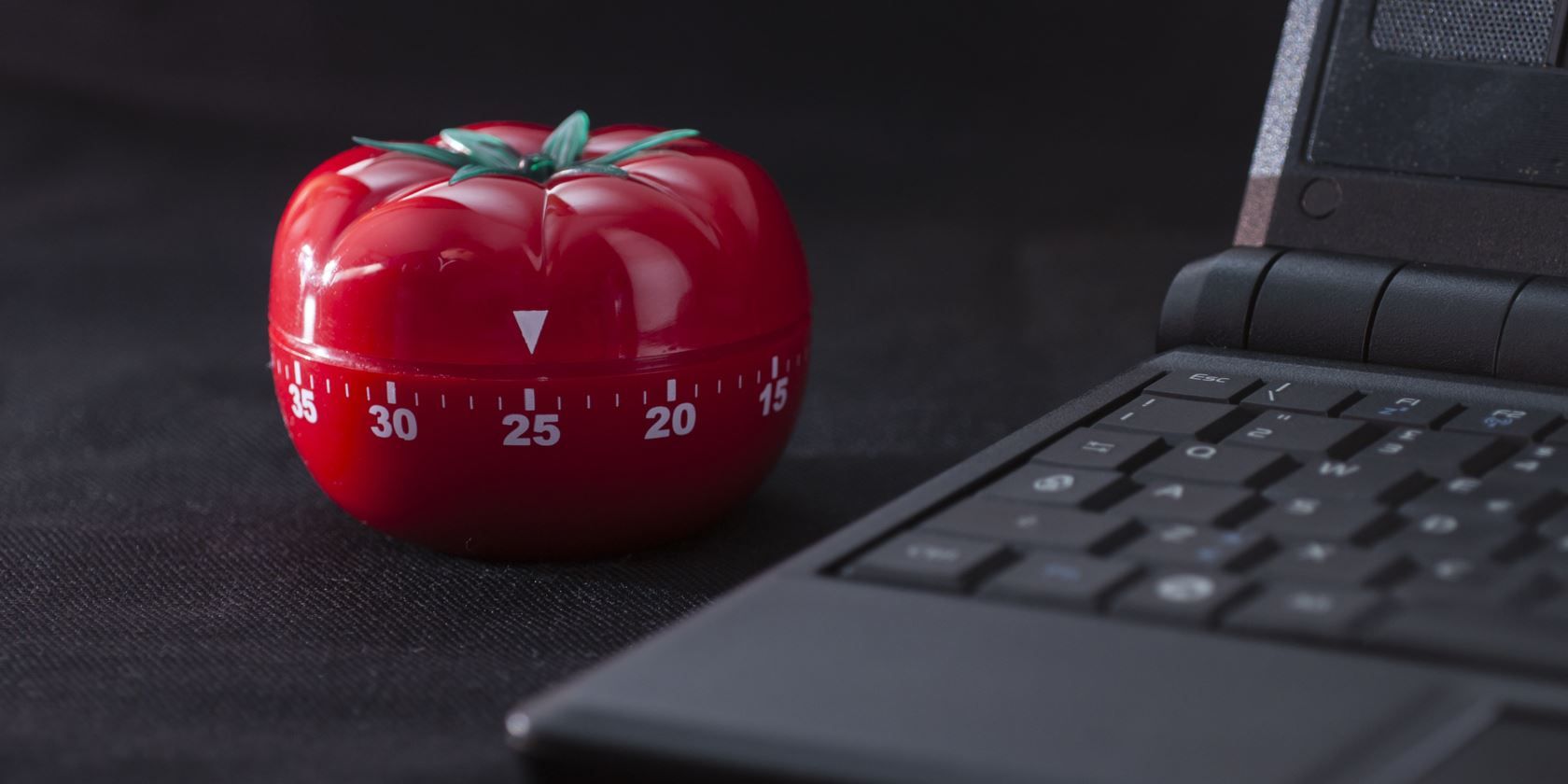 Pomodoro timer device beside a laptop