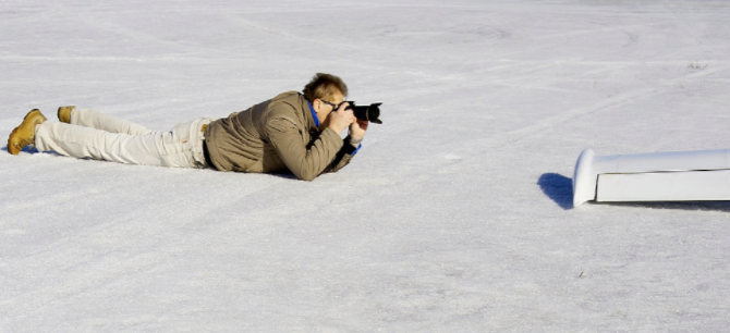 Mann fotografiert liegend
