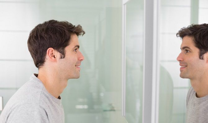 man looking at self in mirror