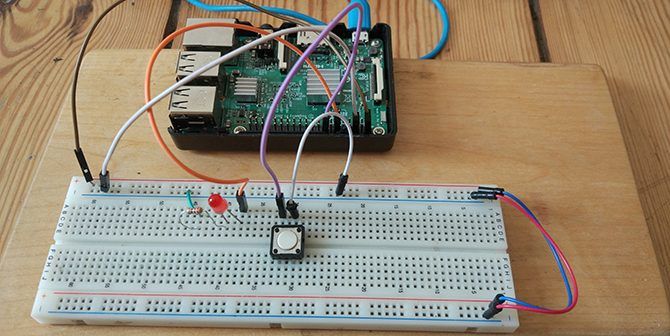 Raspberry Pi hooked up to a button and LED on a breadboard.
