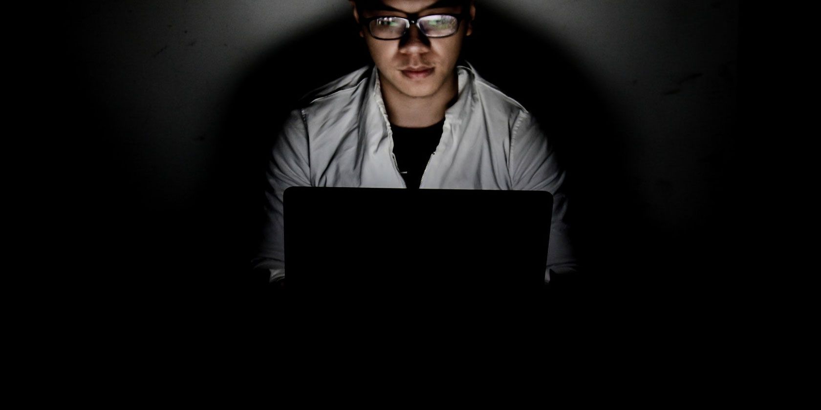 someone using laptop in a dark room