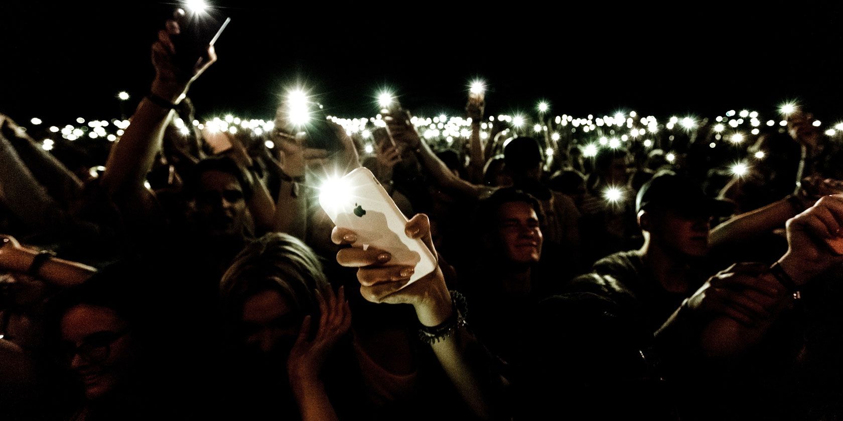 Crowd of people using their phone flashlights