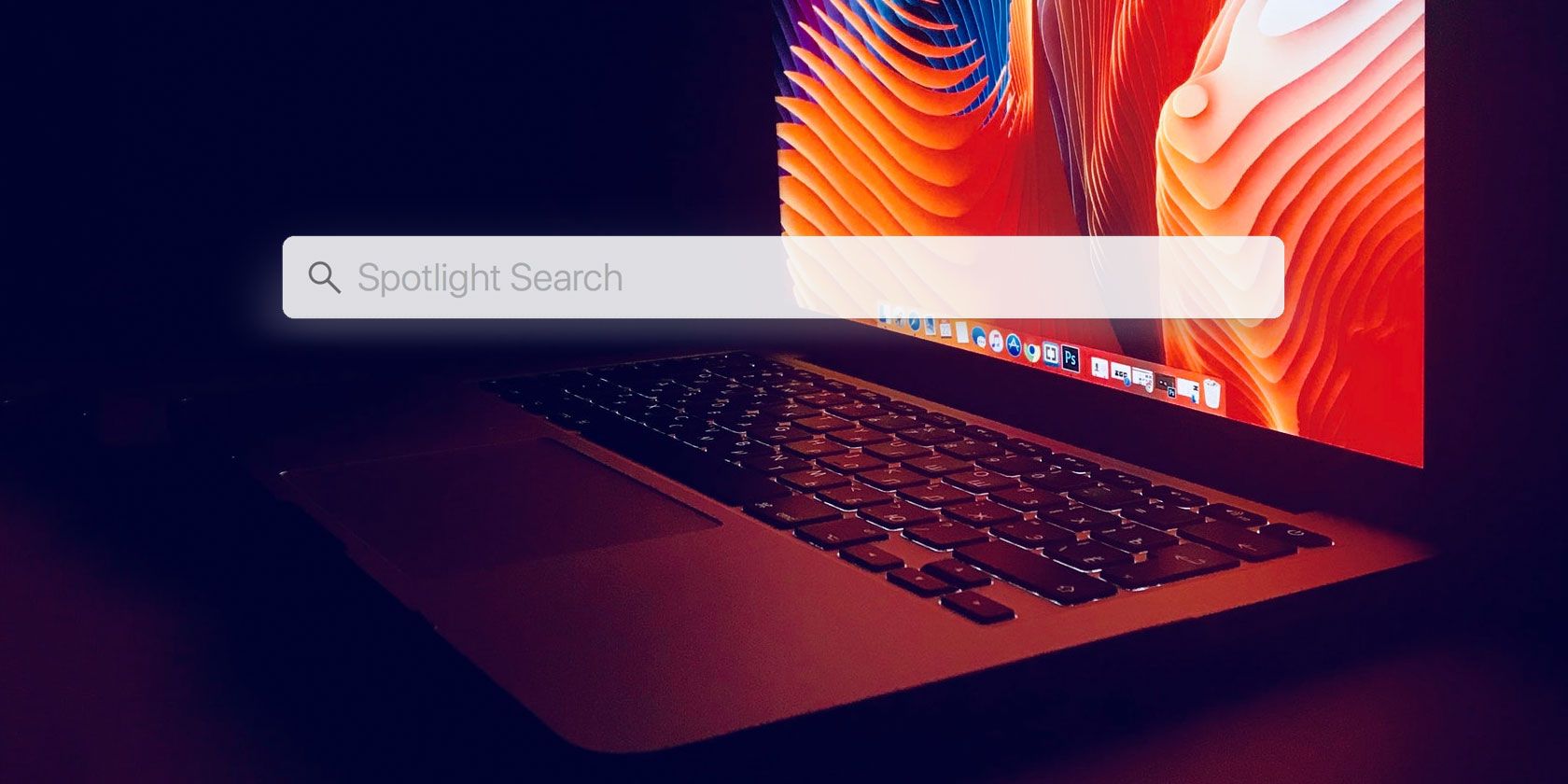 Spotlight search bar in front of a MacBook