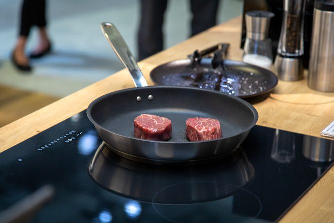 Steaks frying on Miele smart stovetop