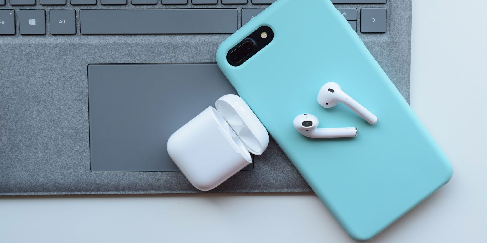 AirPods on top of an iPhone and laptop