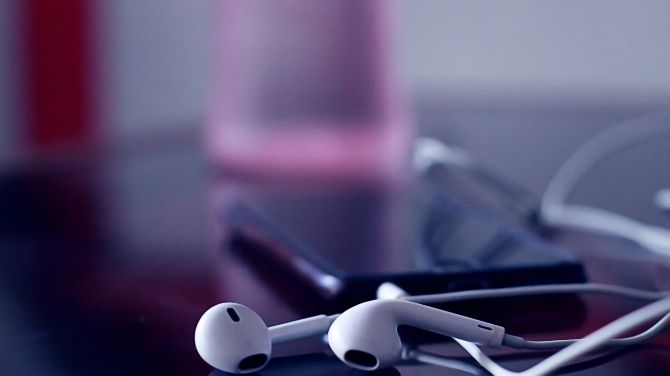 EarPods lying next to iPhone with colorful background