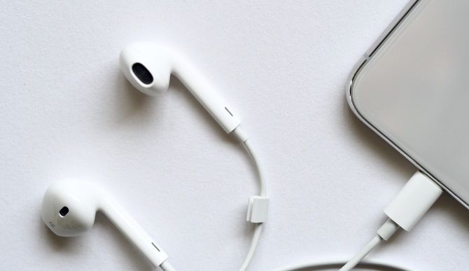 EarPods plugged in to iPhone on a white surface