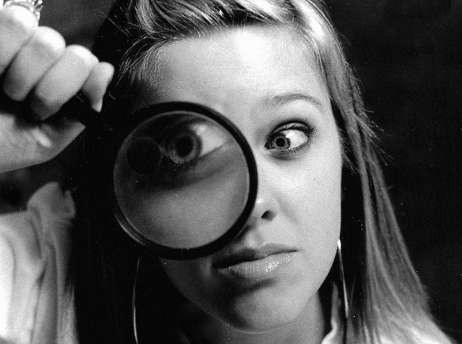 a woman holding a magnifying glass to her eye