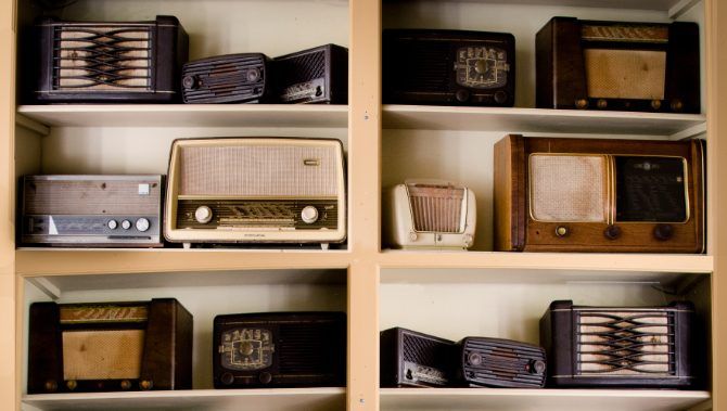 Old analog radios on a bookshelf