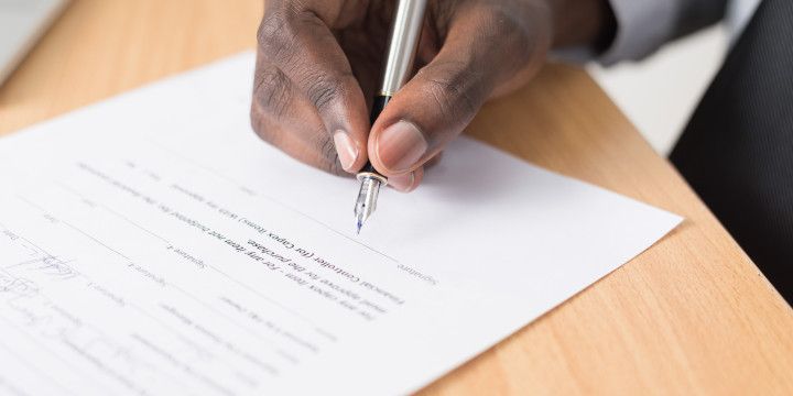a hand signing a contract