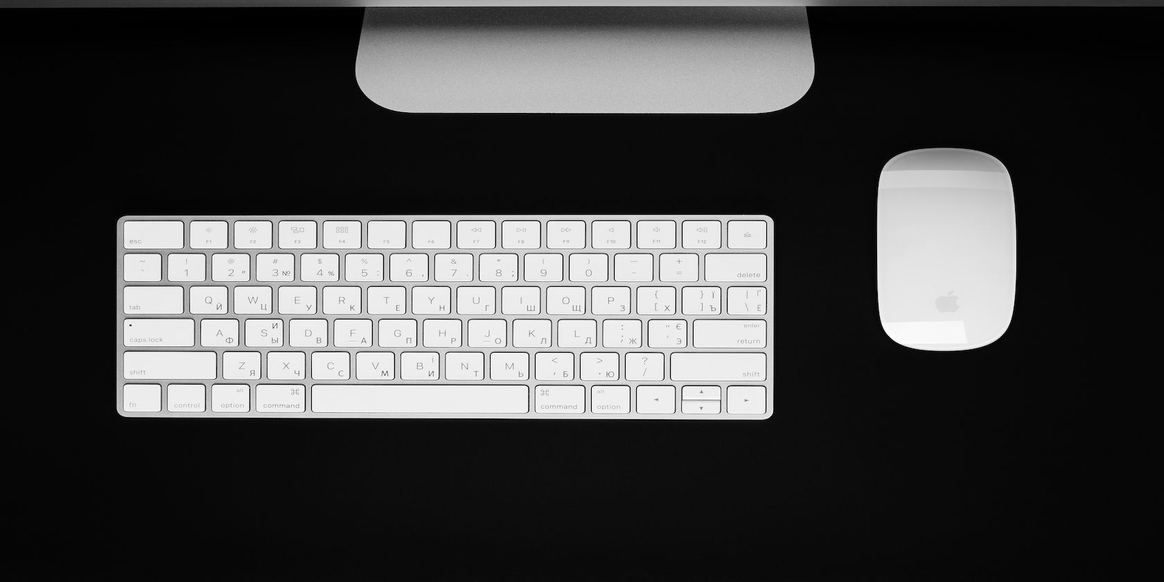 Apple Magic Keyboard on a desk next to a mouse