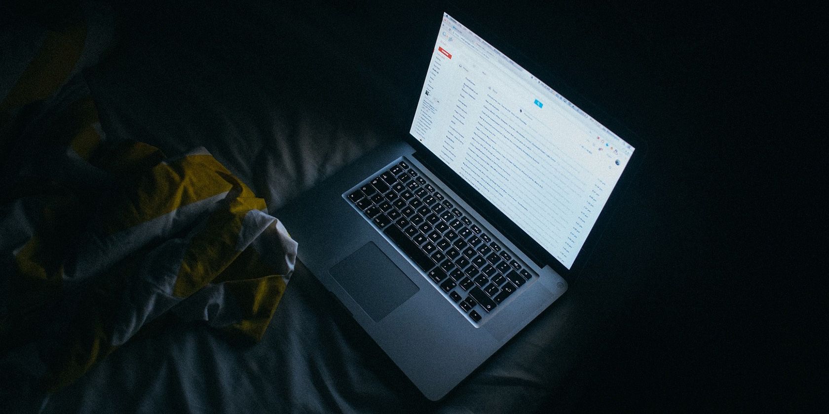 Gmail inbox showing on a laptop screen in a dark room