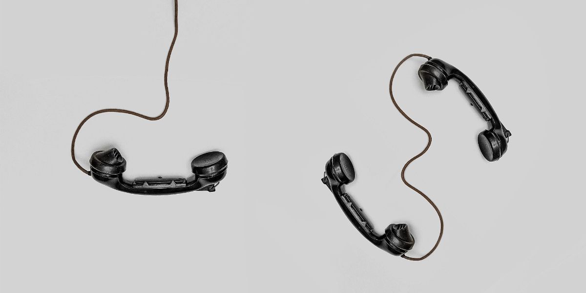 Three black phone handsets two connected