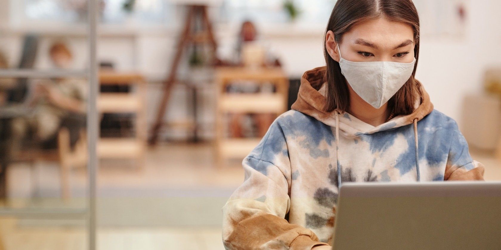 Girl wearing mask working on a laptop