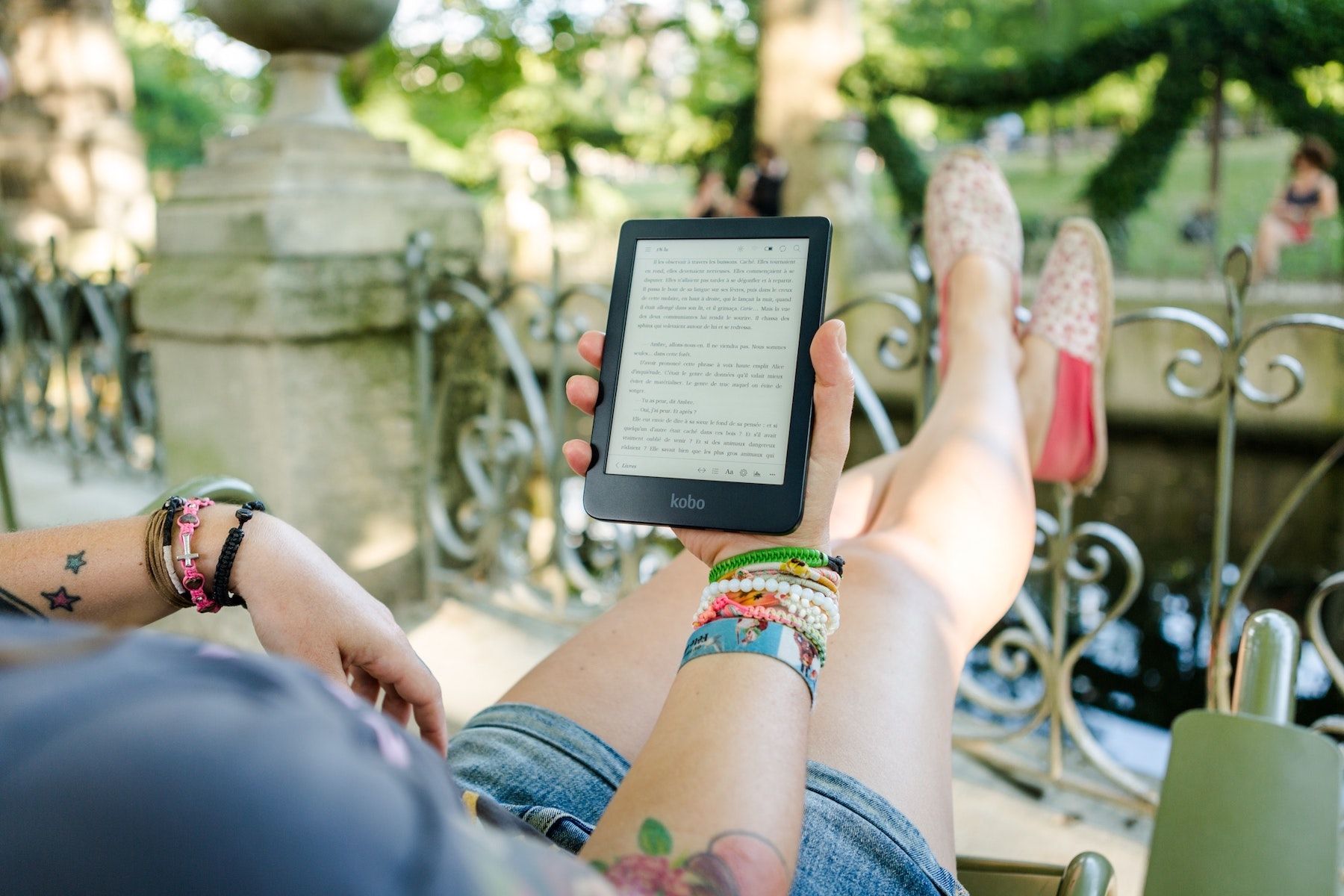Person reading a Kobo ereader with their feet up