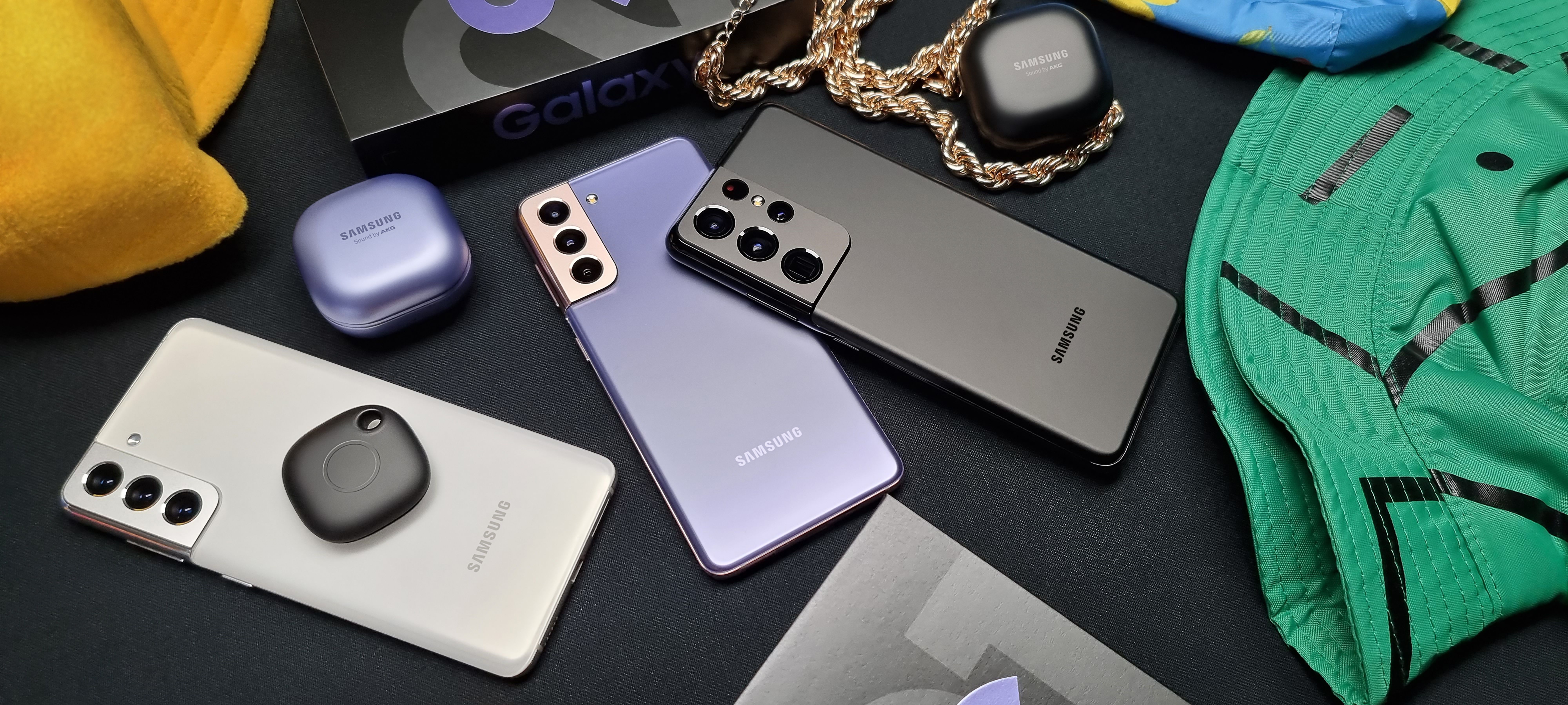 The Samsung S21 series phones on a table with some accessories