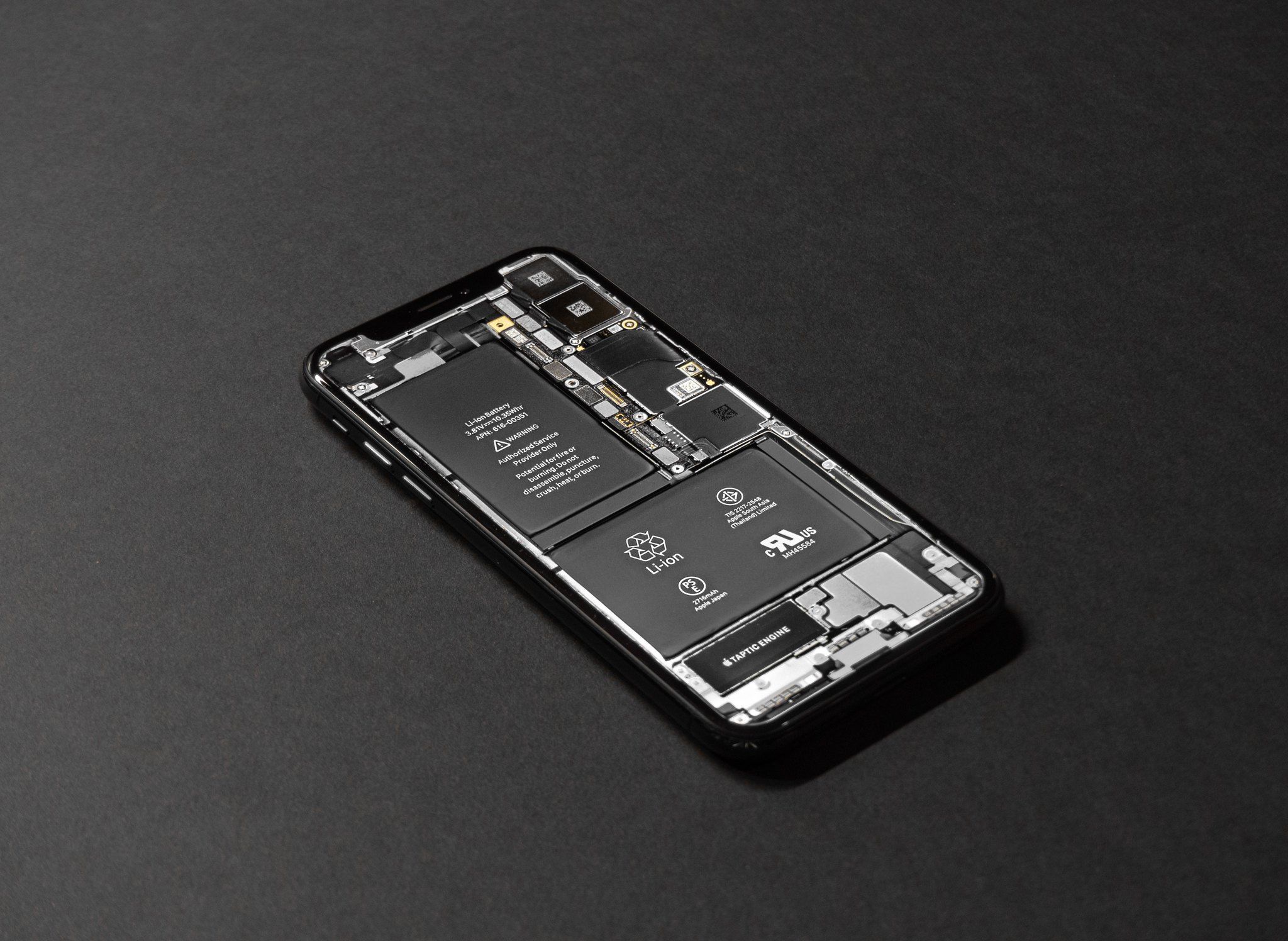 A black android phone with the battery and circuitry exposed