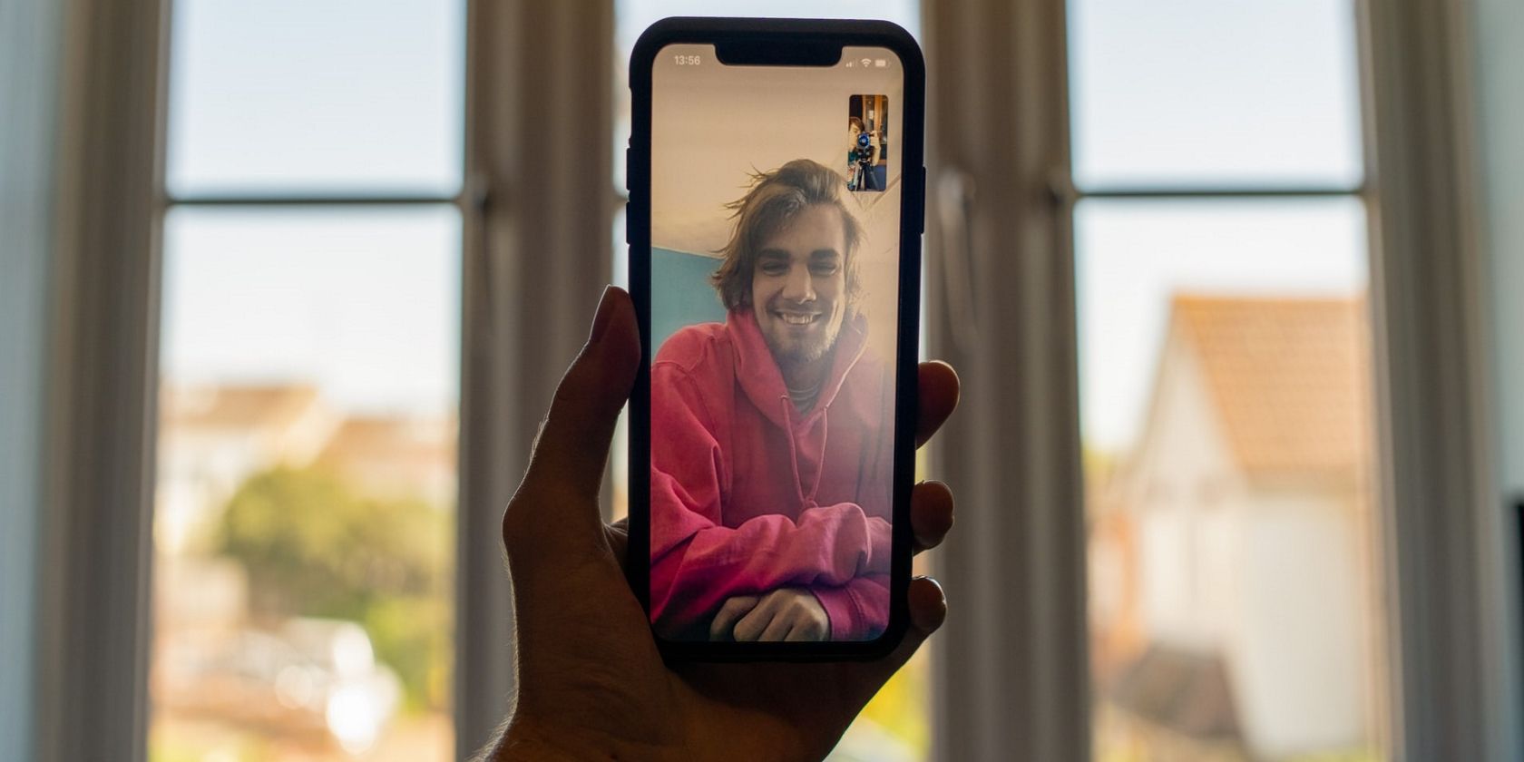 Hand holding a smart phone in a video call