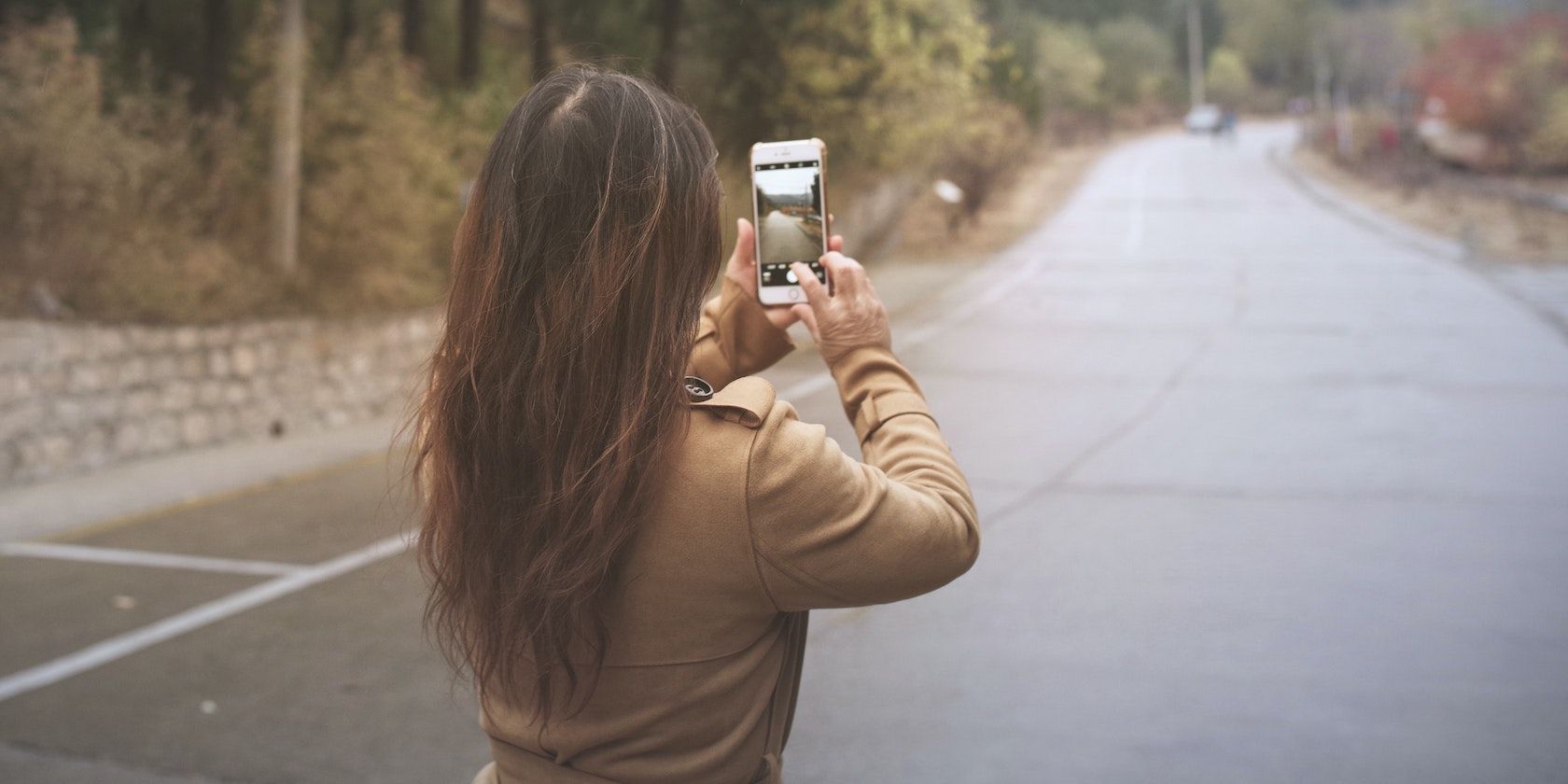 a girl taking photos of the road on iPhone