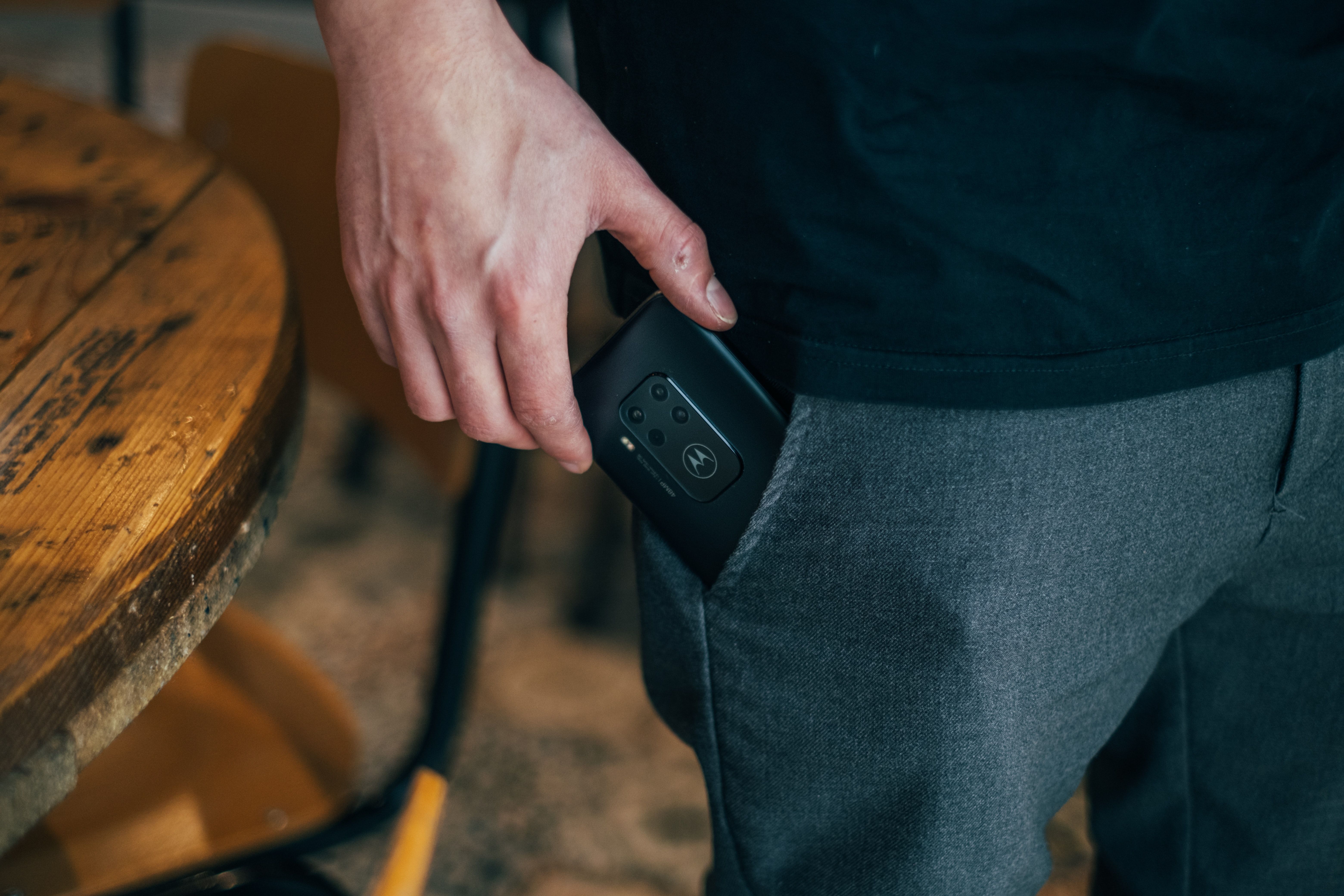 A Motorola phone being put into a pocket where lint and dust could accumulate inside the audio jack