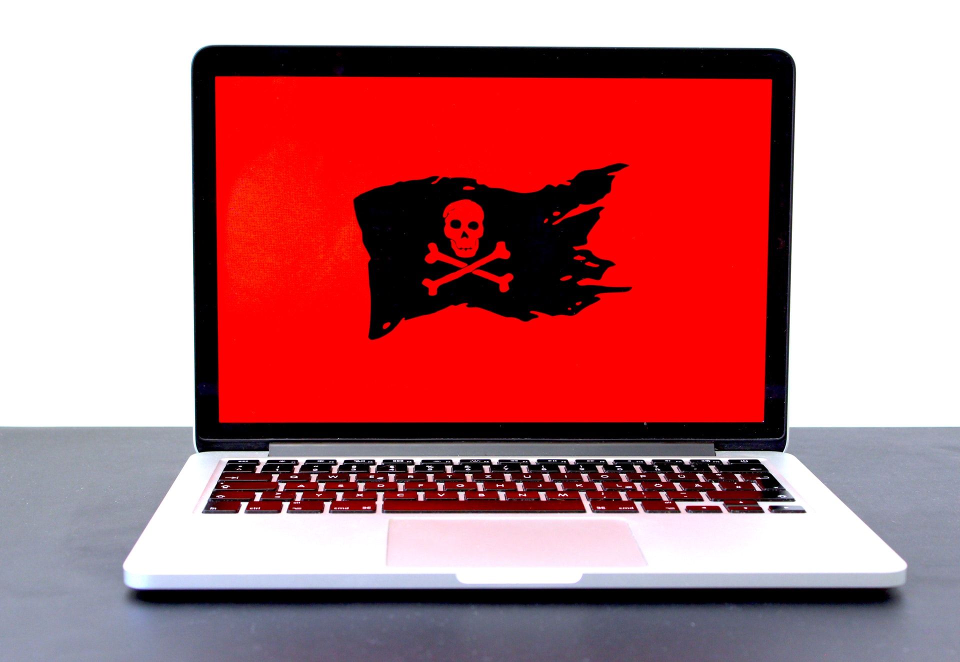 Laptop with a red screen and black pirate flag