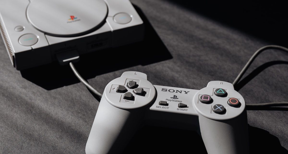 A PS1 console with a controller plugged in