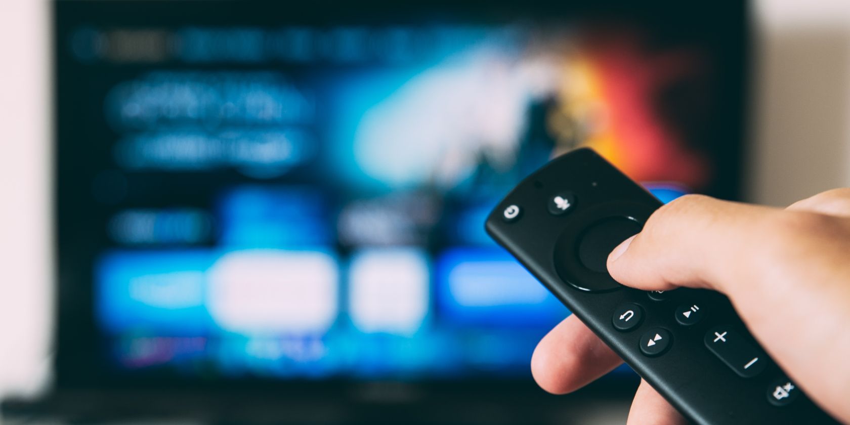 tv remote in front of a blurred TV display