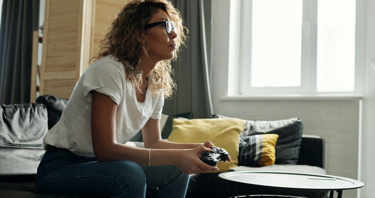 A woman playing a game, holding a wireless controller