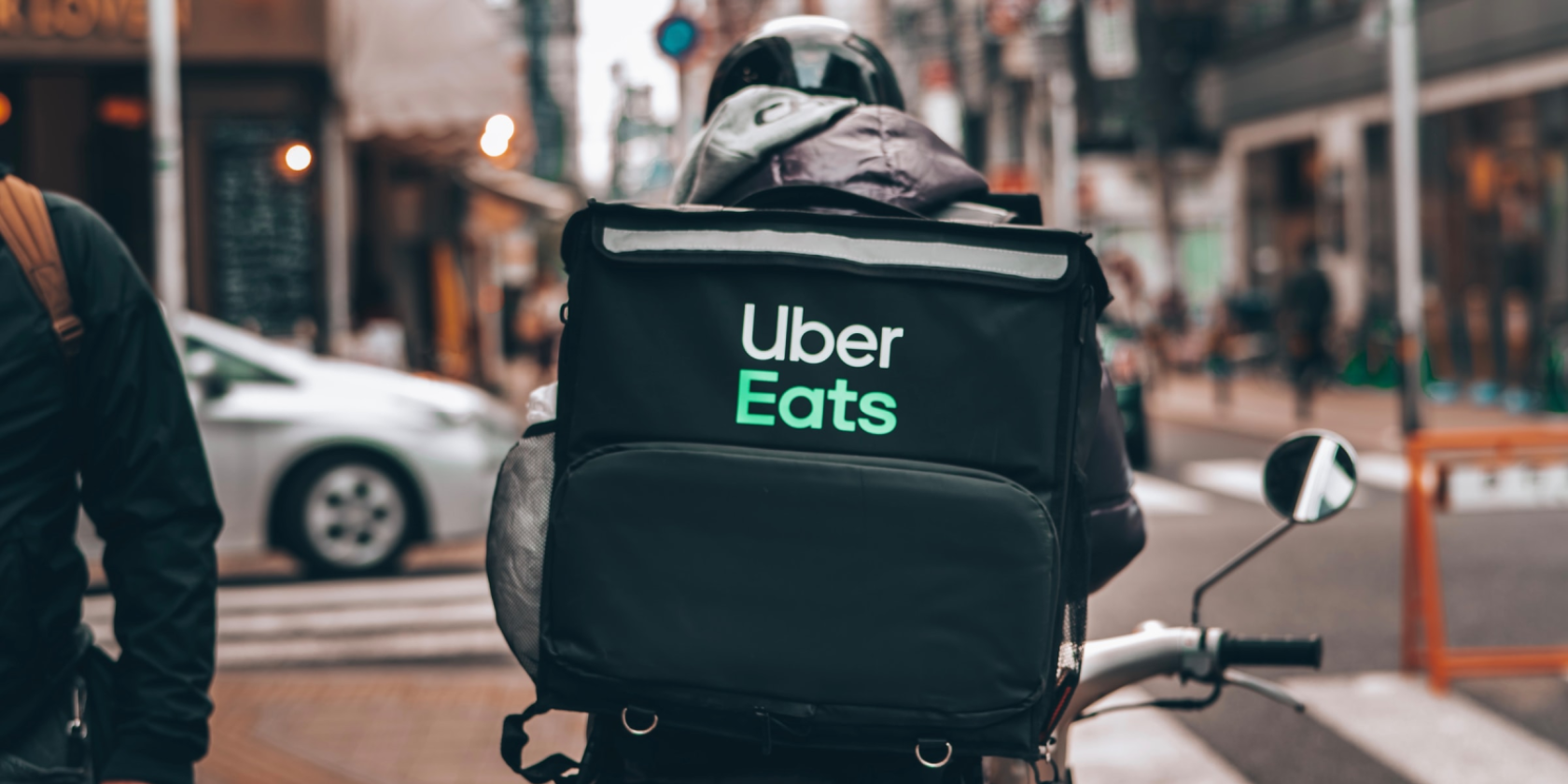 Uber Eats food delivery bike driving through traffic