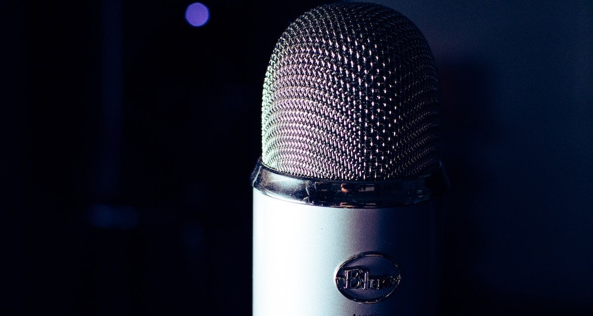 Blue USB microphone, half covered in shadow.