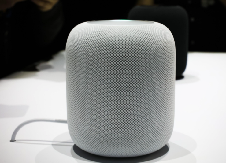 A white Apple HomePod on a table