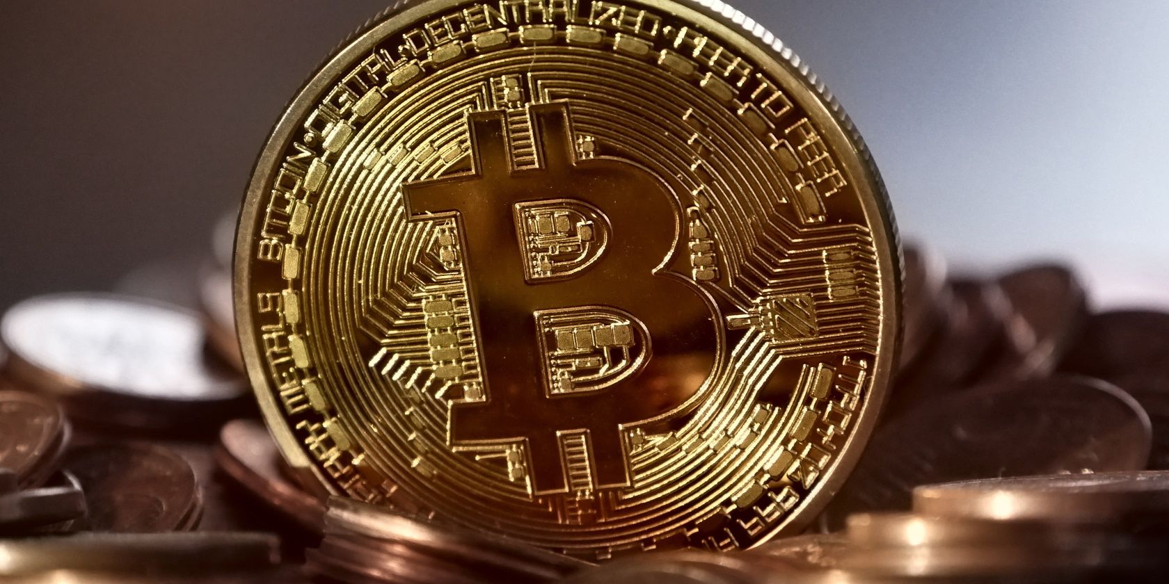 A golden coin with Bitcoin's symbol on it among other golden coins.