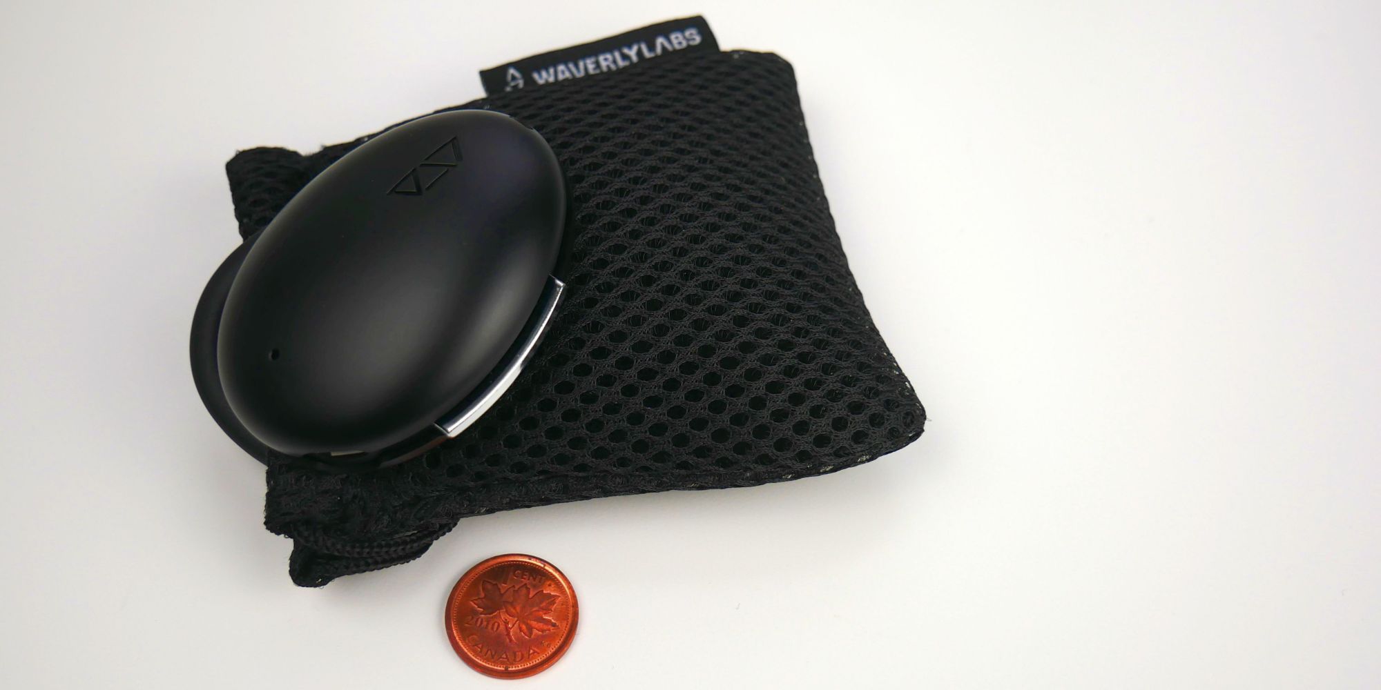 Waverly Labs Ambassador Interpreter earpiece with pouch and penny for scale