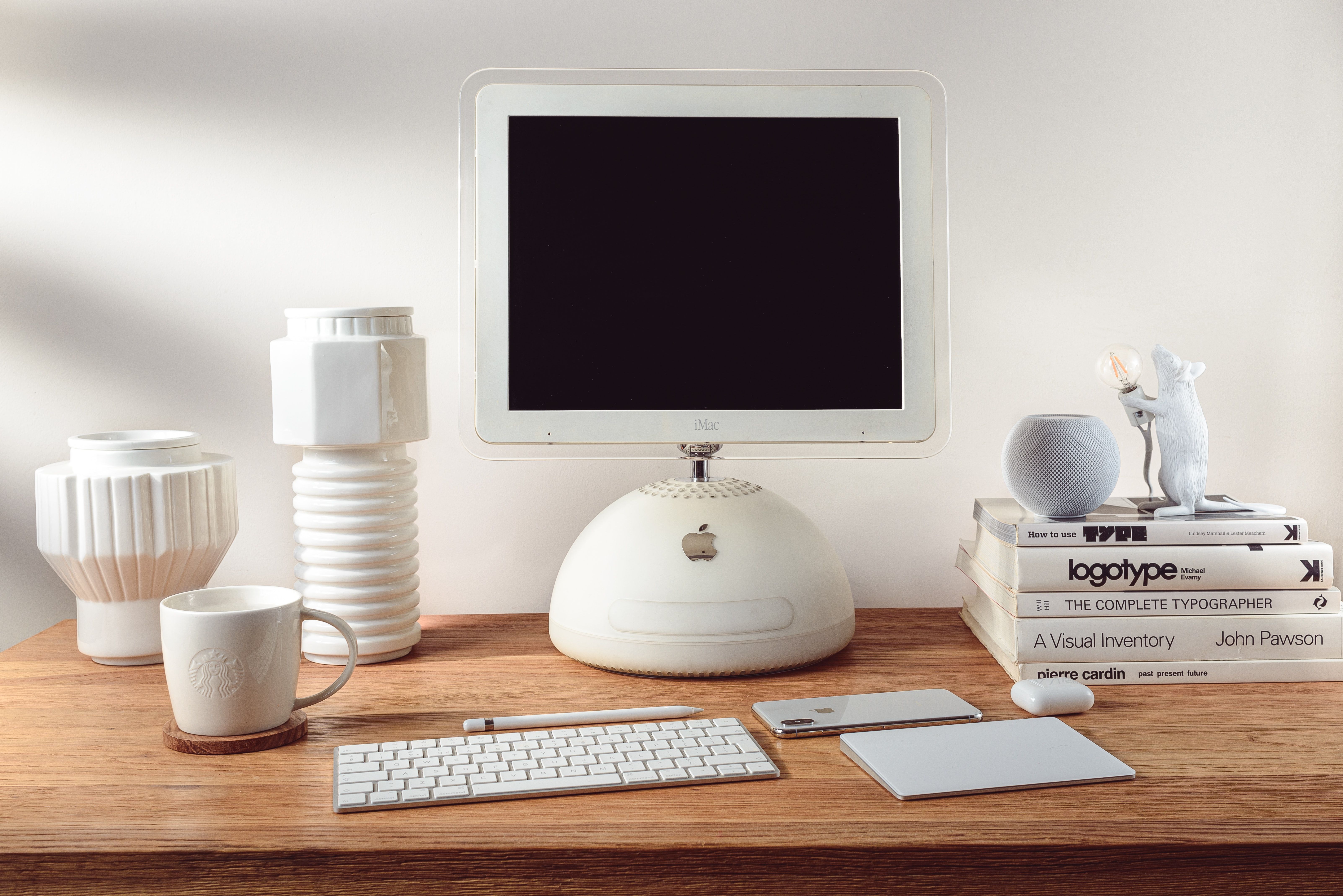 A collection of apple product sincluding a Mac and a HomePod Mini on a desk