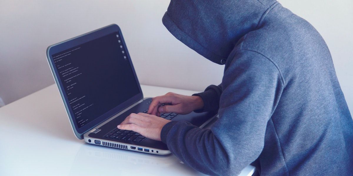 a cybercriminal using a laptop to hack