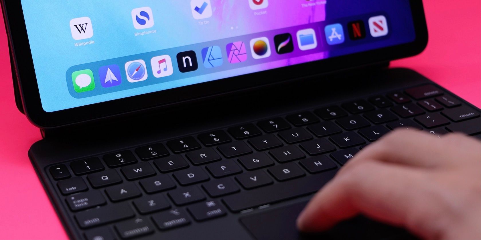 Hand touching trackpad on Magic Keyboard for iPad