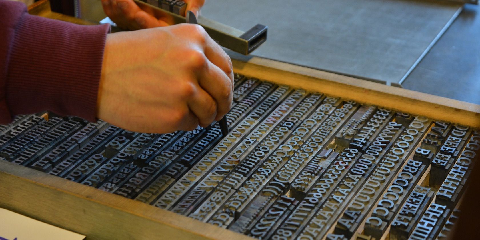 Pair of Human Hands Preparing a Printing Press