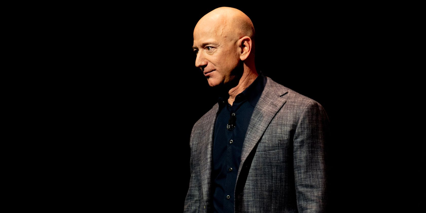 Jeff Bezos wearing a suit with a dark background