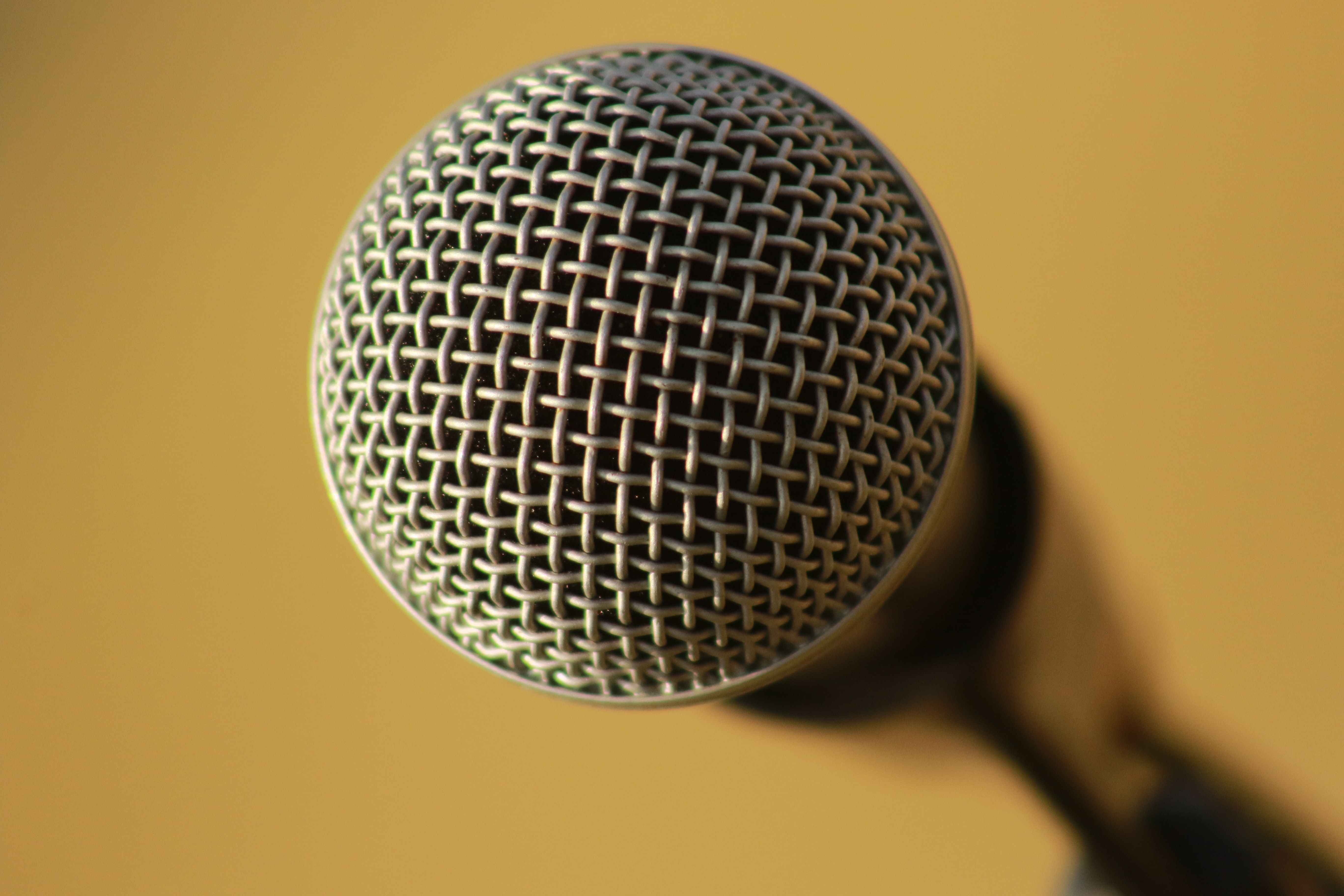 A microphone in shallow focus on an orange background