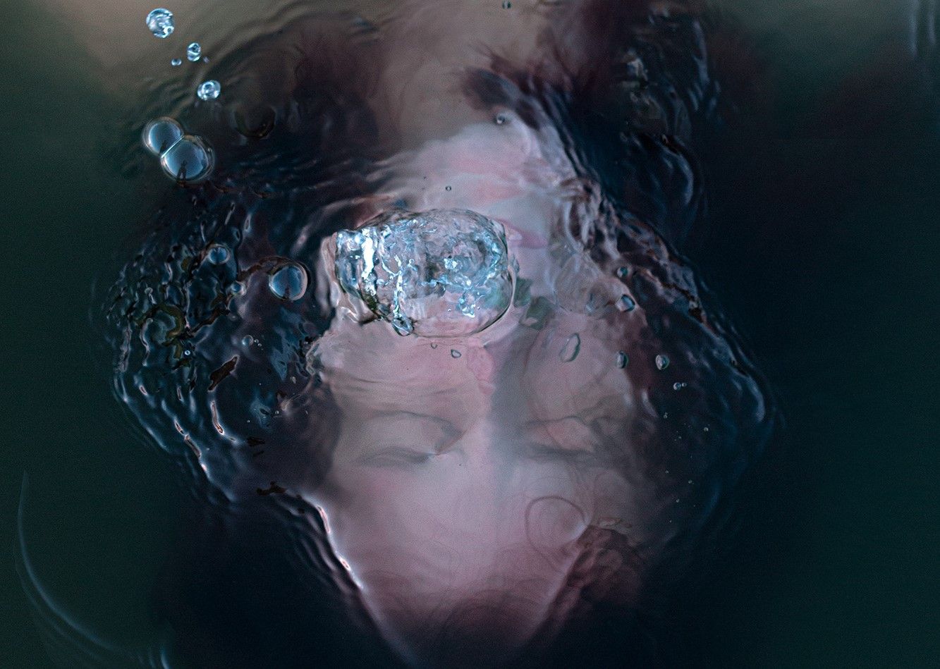 person underwater with bubbles