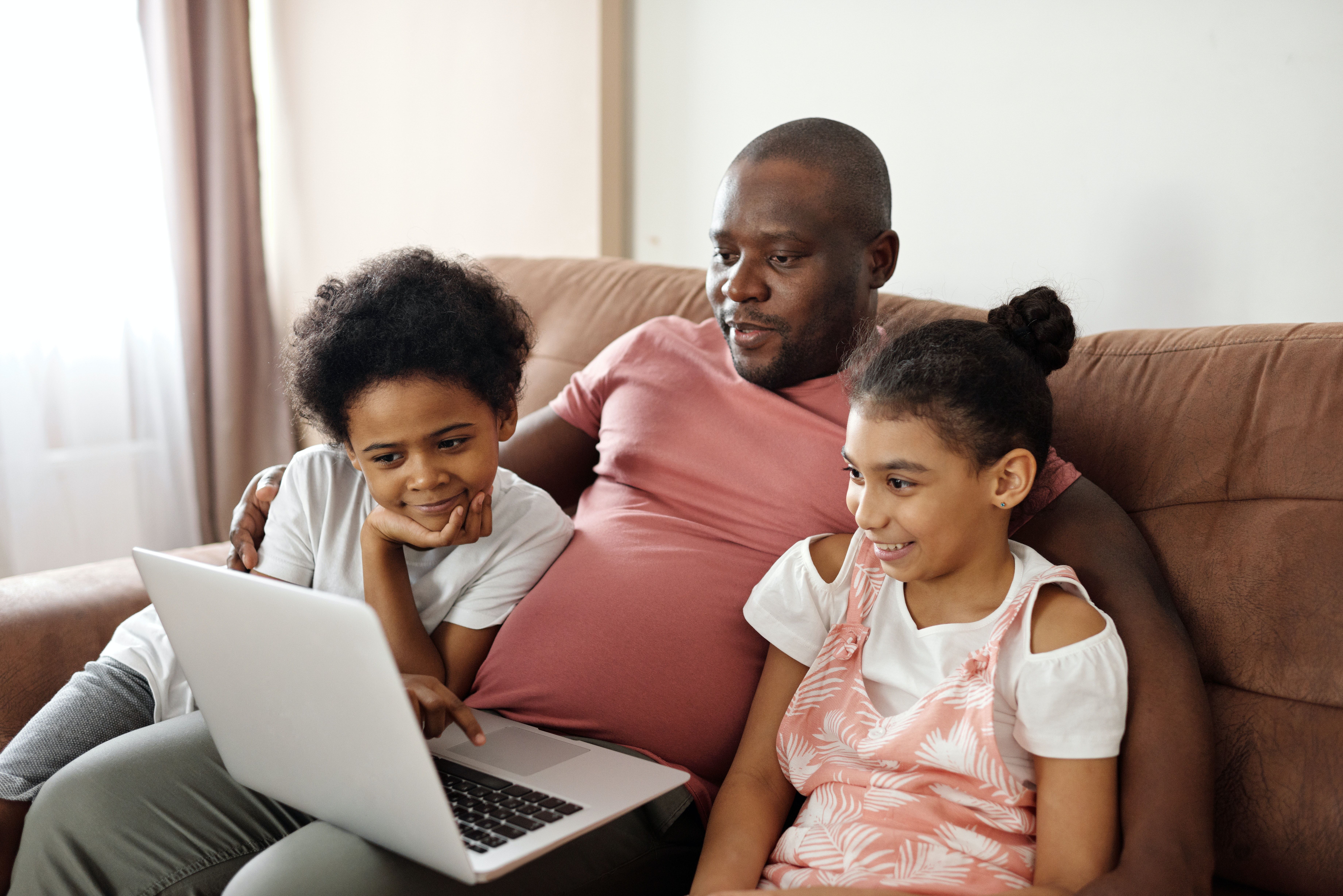 Man with two children watching computer