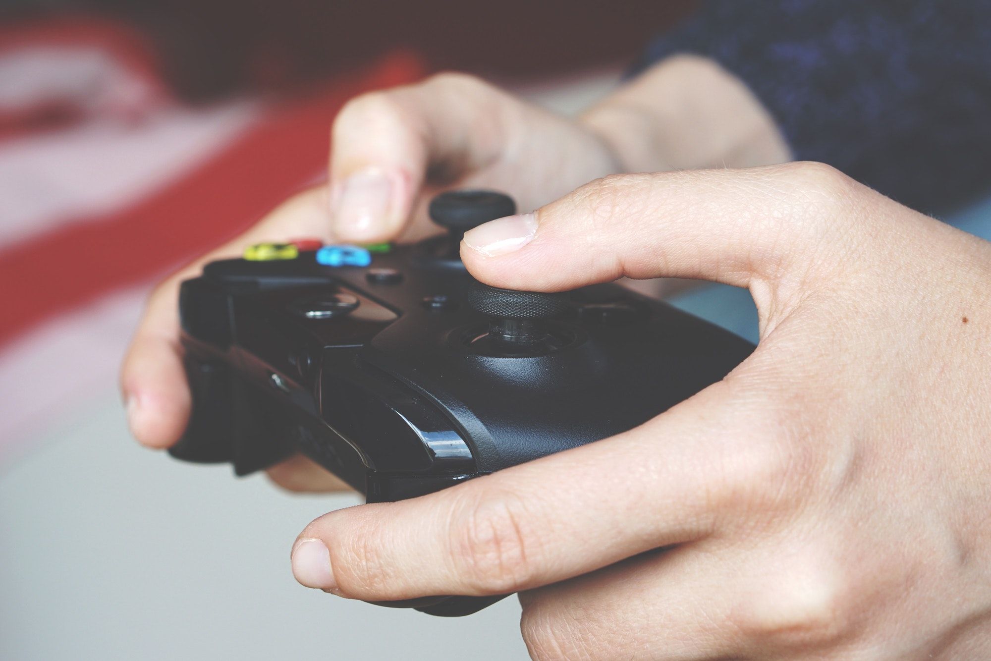 A wireless Xbox controller held by two hands.