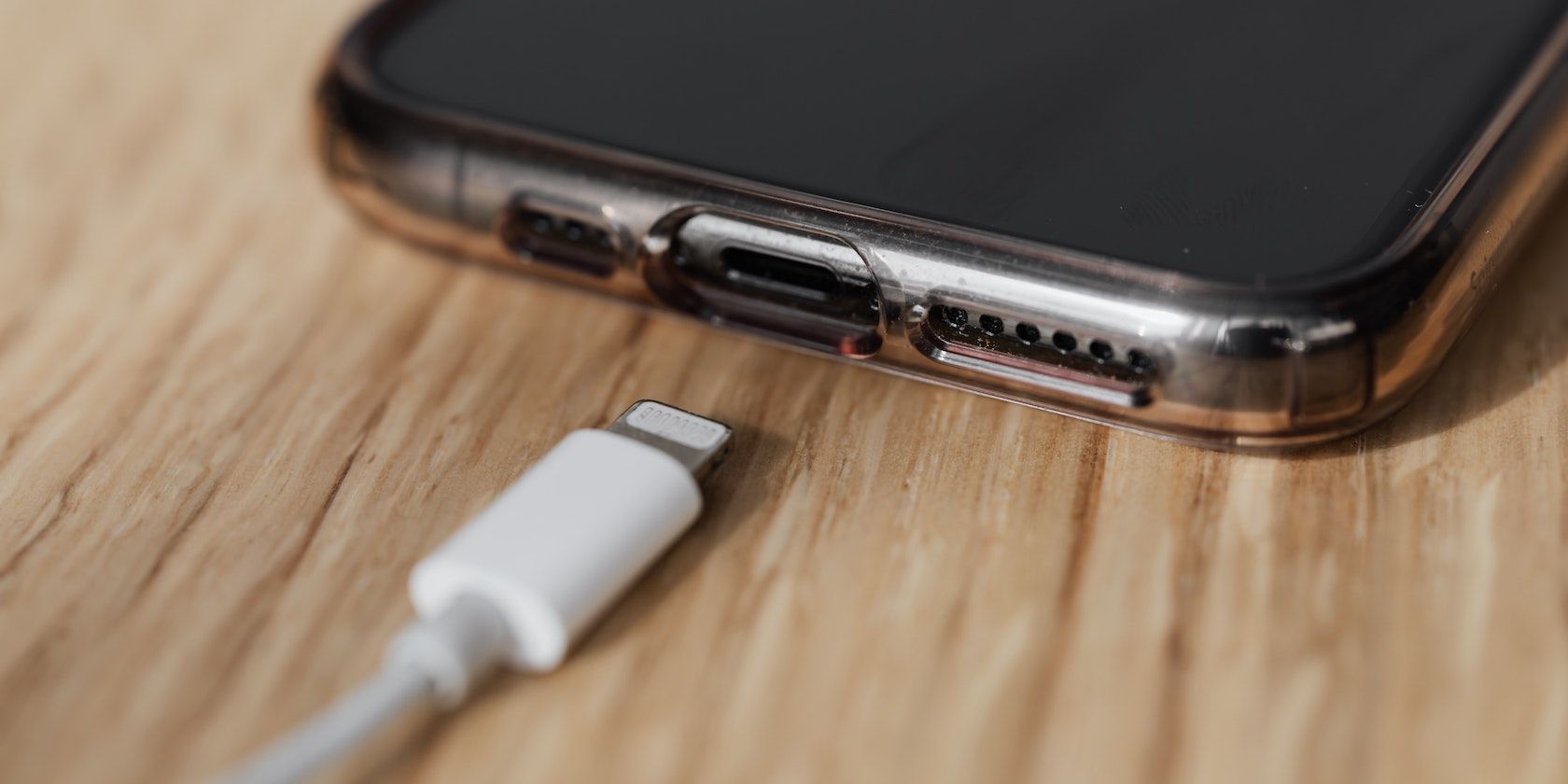 A lightning cable sits just below an iPhone, about to be put in