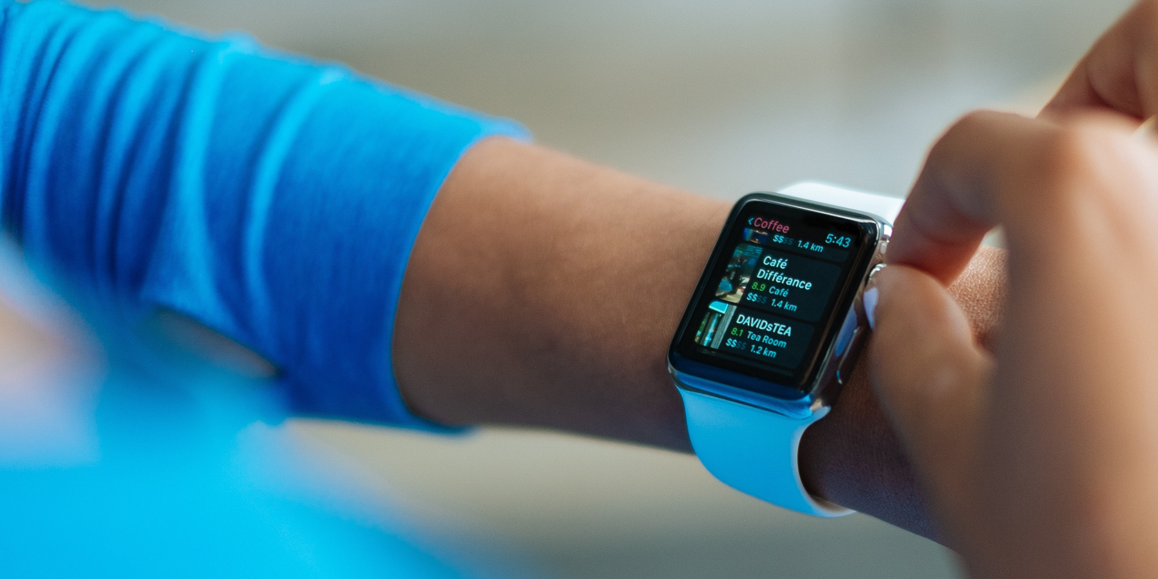 Person wearing blue manipulating his Apple Watch